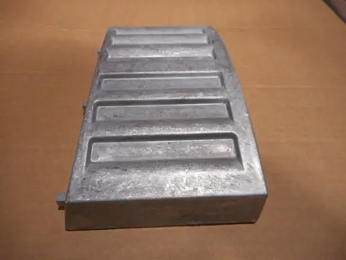 Aluminium-Luftkasten von Remeha, rechteckiges Element mit fünf horizontalen Rillen, auf braunem Karton hinterlegt.